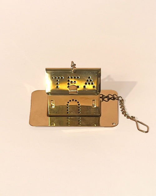 An house shaped infuser in gold color