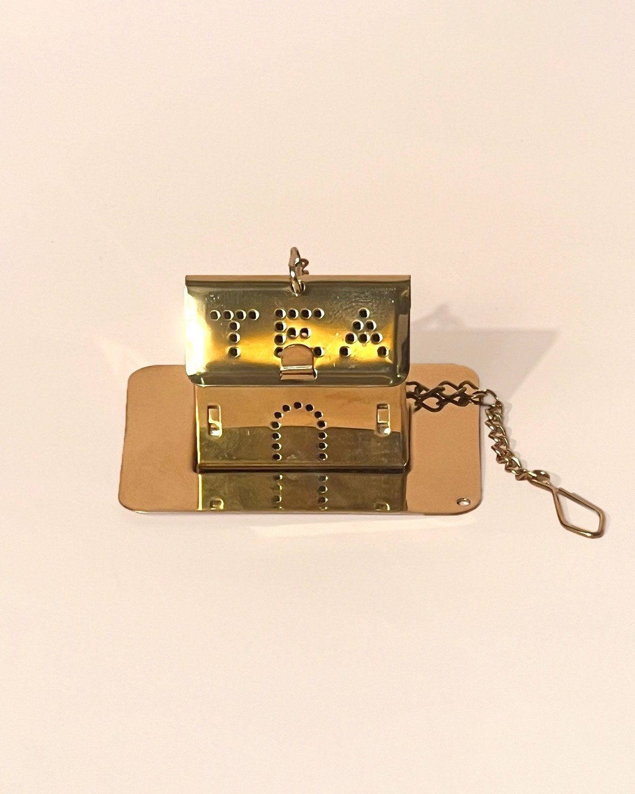 An house shaped infuser in gold color